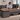 Office worker reviewing documents at a Lurpes L-shaped desk with a computer and everyday work supplies