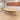 Light wood oval meeting table with beige legs and dark curved apron — full office view in the same office