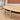 Light wood oval meeting table with beige legs and dark curved apron — detail of original visible surfaces in the same office