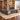 Gray wood executive desk with left storage return and geometric cabinet fronts in a furnished office, 45-degree view