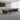 Dark wood conference table with pale central cable strip, framed plinths and two silver modesty-panel lines — full office view in the same office