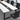White and charcoal rectangular conference table with three loop supports and two cable ports, visible surface detail in the same office