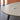 Light gray oval conference table with six black legs and two silver cable covers — detail of original visible surfaces in the same office